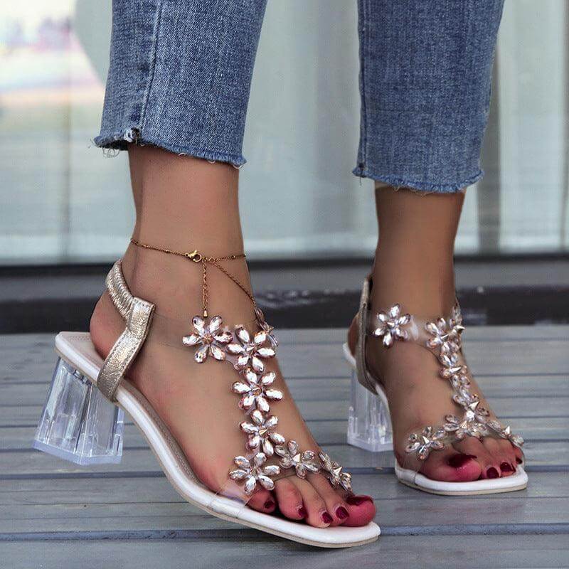 Woman wearing fashion flower sandals with transparent square heels and jeans, showcasing summer shoes with a unique and stylish design.